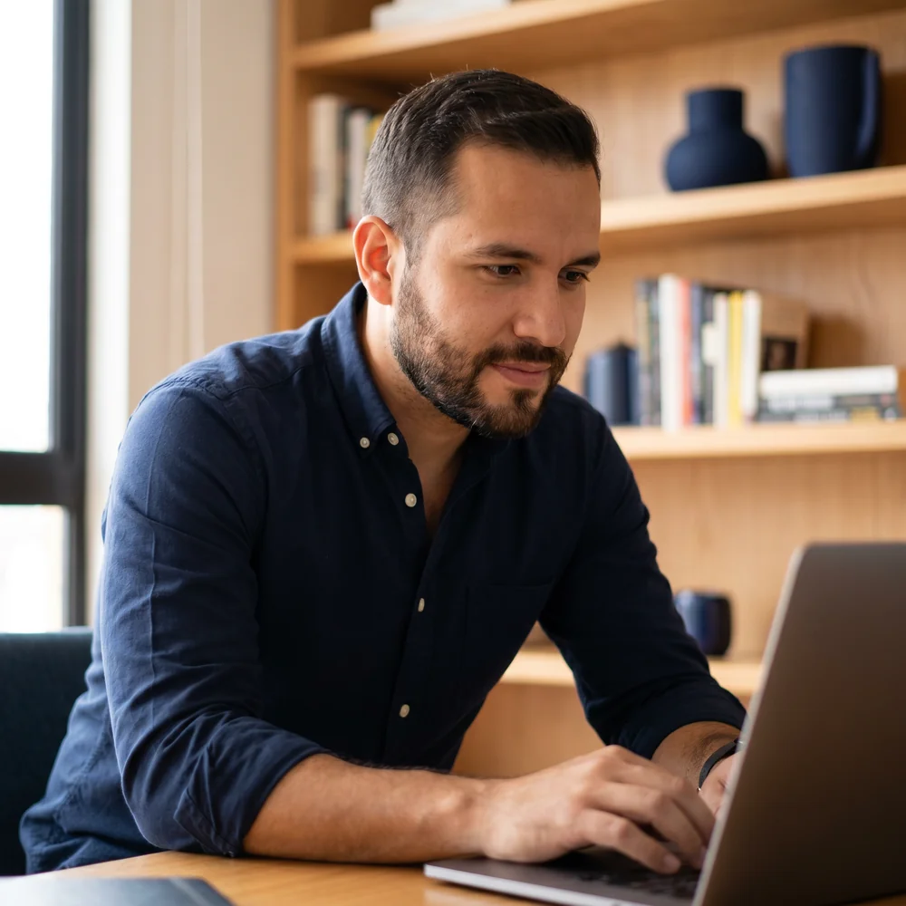 Editorial photograph of a focused, determined entrepreneur working on a laptop